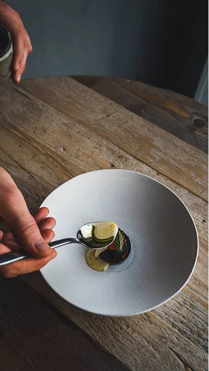 Photo d'une assiette dans laquelle on verse de la sauce