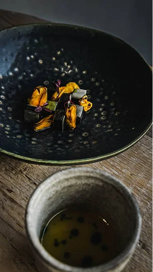 Photo d'une assiette où sont dressées des moules avec un bol de sauce à côté