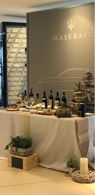 photo d'une table sur laquelle est placée pièces salées et des bouteilles de vin pour un événement Maserati