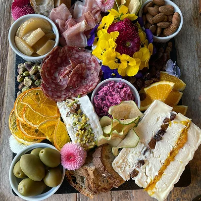 photo d'une table de buffet dressée pour un événement dans une grande salle où se trouve un tableau exposé